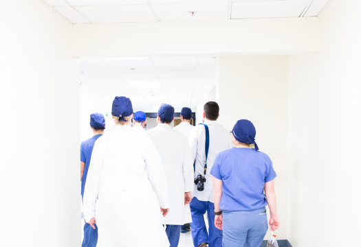 A group of doctors walks away down a corridor